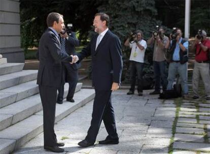 José Luis Rodríguez Zapatero recibe a Mariano Rajoy al pie de las escaleras del palacio de la Moncloa.