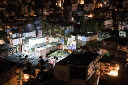 Unas personas usan sus teléfonos móviles mientras están sentadas encima de una tumba, mientras visitan a sus seres queridos en el cementerio de Barangka en Marikina, al este de Manila.