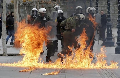 Las llamas rodean a varios agentes de la policía griega tras los enfrentamientos con un grupo de radicales durante la jornada de huelga general en la plaza Syntagma de Atenas (Grecia).