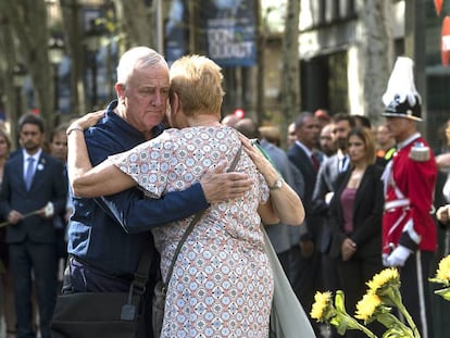 Dos familiares se abrazan después de depositar unas flores en el mosaico de Joan Miró de La Rambla de Barcelona.