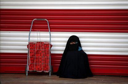 Una muchacha cubierta con un chador descansa junto a una tienda cerrada en Sanliurfa (Turquía).