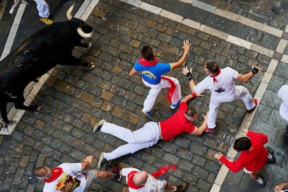 Een renner valt op de grond tijdens de eerste stierenrennen van San Fermín op maandag.