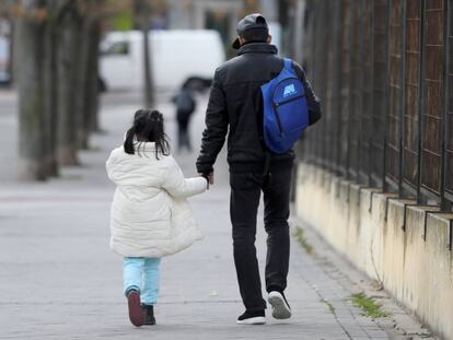 Un demandante de asilo vuelve con su hija al centro del Samur Social en la calle de Rafael Alberti.