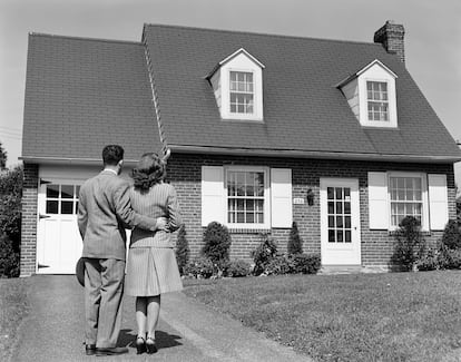 Pareja de los años cuarenta contempla una de los típicos chalets periféricos.