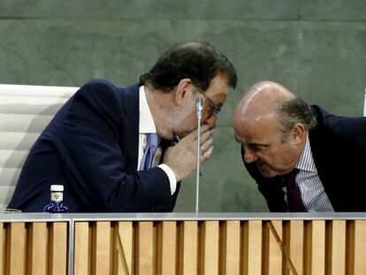 El presidente del Gobierno, Mariano Rajoy, habla con Luis de Guindos, ministro de Economía.