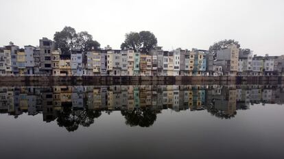 Casas residenciales se reflejan en un lago en Hanoi (Vietnam).