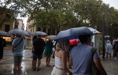 Personas caminan por Palma (Mallorca) con paraguas en un día de lluvia, en septiembre de este año.