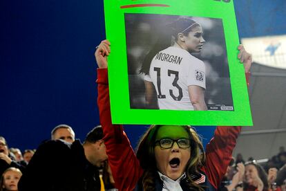 Una aficionada sostiene un cartel con la imagen de la delantera de la selección estadounidense.