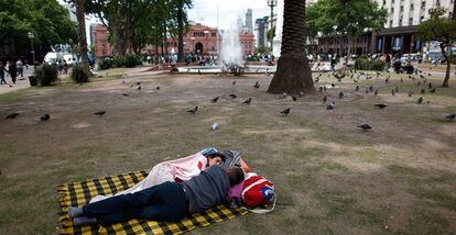 Una pareja duerme en la Plaza de Mayo, a las afueras de la Casa Rosada, en Buenos Aires.