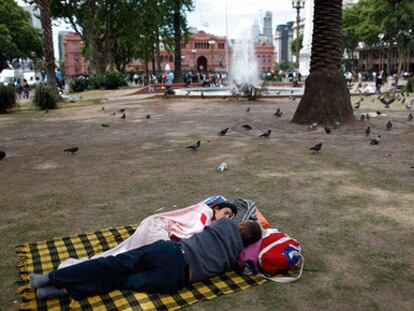 Una pareja duerme en la Plaza de Mayo, a las afueras de la Casa Rosada, en Buenos Aires.