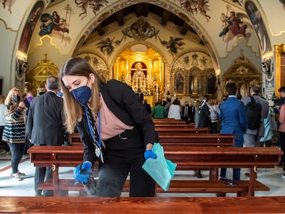 Uma jovem desinfeta os bancos da igreja de Santa Genoveva, em Sevilha (Espanha).