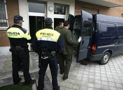 Empleados de los Servicios Funerarios introducen en un furgón el cadáver de la mujer.