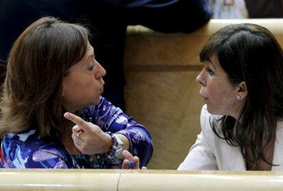 La senadora de CiU Montserrat Candini (izquierda) charla con la del PP Alicia Sánchez-Camacho durante el pleno del Senado