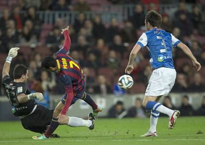 El delantero del F.C. Barcelona, Pedro Rodríguez (c), lucha el balón con el portero Eñaut Zubikarai (i), de la Real Sociedad, durante el encuentro de ida de la semifinal de la Copa del Rey que se disputa esta noche en el Camp Nou, en Barcelona.