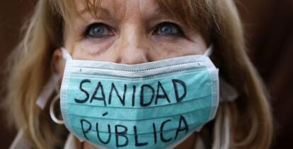 A protestor defends public heathcare outside the Madrid regional High Court.