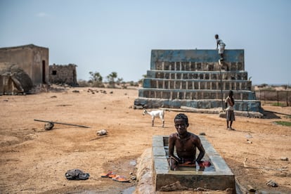 Un joven afar aprovecha para darse un baño en su poblado, cercano a una de las excavaciones, en la zona de Abou Yousuf, a unos pocos kilómetros por el desierto de la ciudad de Dikhil.