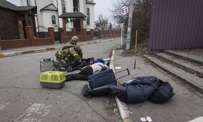 Militares ucranios junto a los cuerpos de una familia que huía de Irpin, cerca de Kiev, este domingo.
