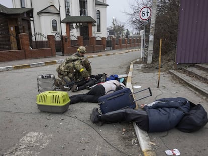 Militares ucranios junto a los cuerpos de una familia que huía de Irpin, cerca de Kiev, este domingo.