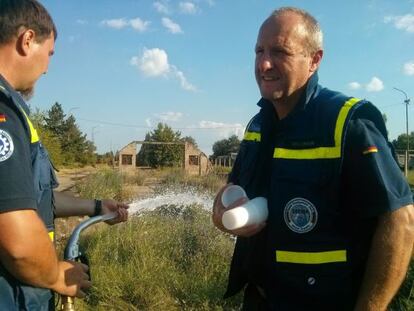 Silvio Volkmann (a la derecha) sostiene unos vasos para mostrar el agua que su equipo ha purificado en Obrenovac.