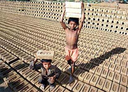 Dos niños transportan ladrillos en una fábrica de Chandigam (India).