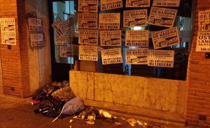 Fachada de una de las sedes atacadas con basura y carteles.