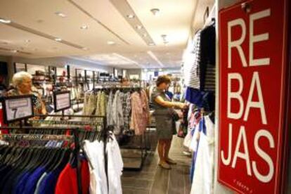 En la imagen, dos mujeres curiosean entre la ropa rebajada en unos grandes almacenes de Valladolid. EFE/Archivo