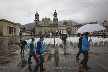 Funcionarios de la alcaldía de Bogotá recorren la Plaza Bolivar momentos antes del acto de inicio del plebiscito por la paz en Colombia. La jornada se ha caracterizado por la lluvia durante la mañana.