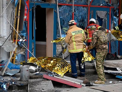 Los bomberos cubrían este jueves los cuerpos de los fallecidos tras el impacto de un cohete ucranio en un centro comercial de Bélgorod.
