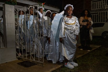 Niñas que interpretan el papel de 'Los Ángeles' se preparan para unirse a la procesión del Nacimiento del Niño Dios Negro.