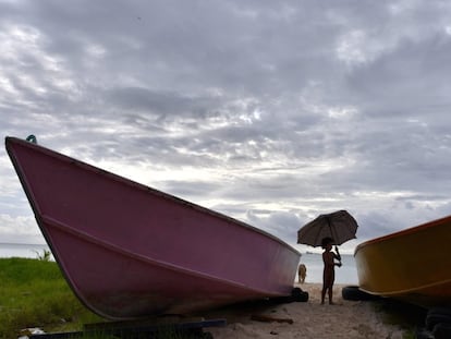 Un niño sostiene un paraguas roto frente al lago de Funafuti (Tuvalu) durante la semana en que se inauguró la 50º edición del Foro de las Islas del Pacífico para fomentar la cooperación entre los gobiernos de los 18 países de la Polinesia, en agosto de 2019