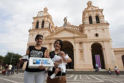 Carina Villarroel y Soledad Ortiz posan con su hija Umma Azul a las afueras de la catedral de Córdoba tras el bautizo.