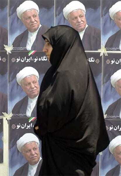 Una iraní pasa delante de los carteles electorales de Rafsanyani en la ciudad de Qom.