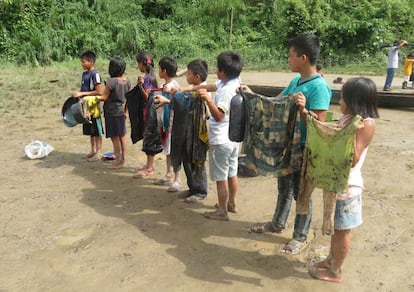 Ni&ntilde;os que recogieron petr&oacute;leo muestran sus camisetas.