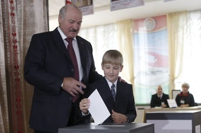El presidente de Bielorrusia, Alexander Lukashenko, junto a su hijo menor Nikolai, deposita su voto en Minsk.