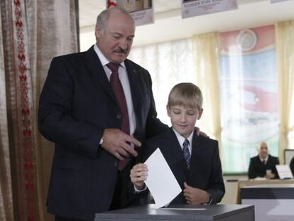 El presidente de Bielorrusia, Alexander Lukashenko, junto a su hijo menor Nikolai, deposita su voto en Minsk.