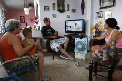 Una familia contempla en la televisi&oacute;n la llegada del papa Francisco a La Habana.