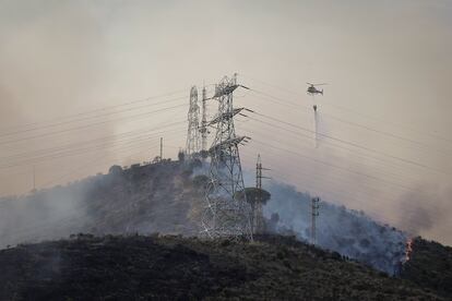 Dotaciones aéreas de los bomberos trabajan en la extinción del incendio en Collserola.