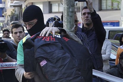 Un agente de la Guardia Civ&iacute;l conduce a un detenido tr&aacute;s el registro en 2009 de un local de la banda &#039;Angeles del Infierno&#039; en Poblenou (Barcelona).