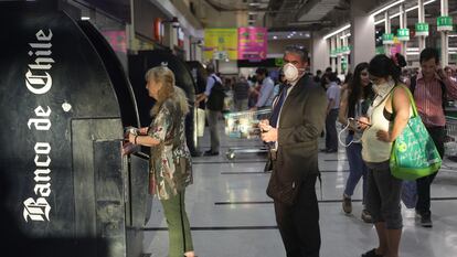 Personas hacen fila para retirar dinero desde un cajero automático en Santiago de Chile, en marzo de 2020.