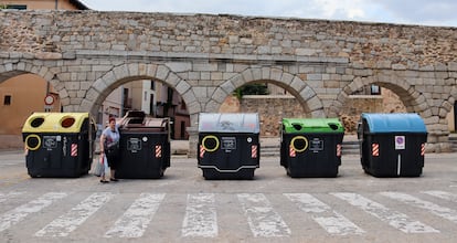 Una vecina echa la basura al cubo orgánico frente al acueducto de Segovia el pasado 9 de julio.