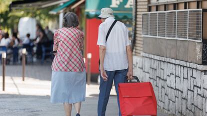 Dos personas mayores caminan por la calle en Madrid.