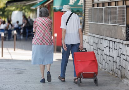 Dos personas mayores caminan por la calle en Madrid.