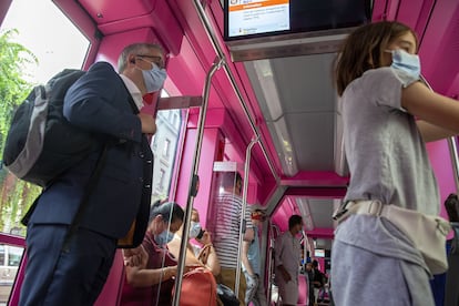 Pasajeros en un autobús en Ginebra (Suiza) se protegen con mascarillas.