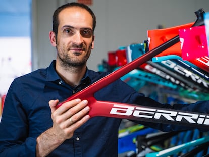 David Vitoria, fundador de Berria Bike, sujeta el marco de una bicicleta.