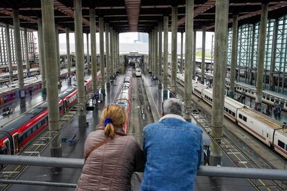  Dos personas miran los trenes de alta velocidad en la estación de Atocha en Madrid. 