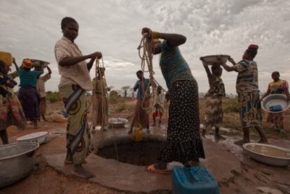 Niños y mujeres sacan agua de los pozos en el campo de refugiados de Kabo.