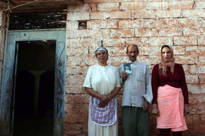 Zahra y Lakbir, con su hija Nazher, a la entrada de su casa en una aldea de Kasba Tadla.