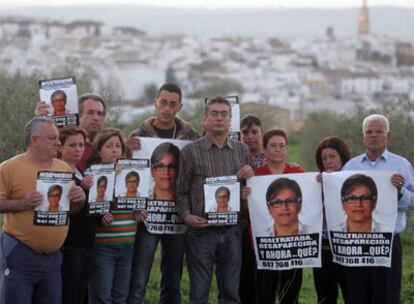 Un grupo de familiares de Ángeles Zurera muestra el pasado viernes carteles con la imagen de la desaparecida, con su pueblo, Aguilar, al fondo.