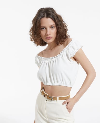 Si buscas una blusa de aire romántico y con un toque bohemio, te gustará este top cropped que deja los hombros a la vista en color blanco de The Kooples.

145€