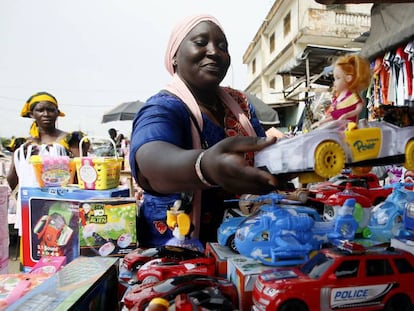 Una vendedora callejera en el pulmón económico marfileño, Abiyán, ordena su mercancía de Navidad.